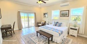 a bedroom with a bed and a desk and windows at The Babbington Villa in Taylor Bay Beach +20 photos