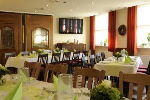 a dining room with tables and chairs with white tablecloths at Gasthof Robens in Dormagen
