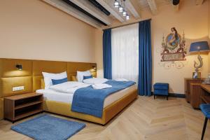 a bedroom with a large bed with a blue blanket at Oysters & Bubbles Gastro Hotel. Rynok square in Lviv