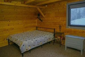 a bedroom with a bed and a window in a log cabin at Independent Chalet in Şirnea