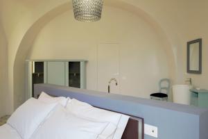 a bed with white pillows in a room at Viaggio Homes Appartamenti da 60 m2 con Jacuzzi Hammam Cucina Patio con Aperitivo di Benvenuto in Faiano +65 photos