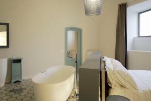 a bedroom with a bed and a table and a chair at Viaggio Homes Appartamenti da 60 m2 con Jacuzzi Hammam Cucina Patio con Aperitivo di Benvenuto in Faiano