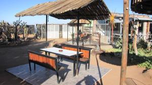 a table and two benches under an umbrella at Canyon Farmyard Camping in Stamprivier