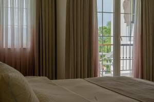 a bedroom with a bed and a window with a balcony at Hacienda Louisandro in Gabrovo +36 photos