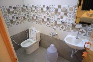 a bathroom with a toilet and a sink at Skytouch Residency-OMR in Chennai