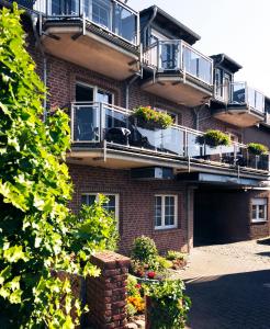 a brick building with balconies and plants on it at Gasthof Robens in Dormagen
