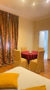 a room with a table with chairs and a red curtain at Paradise Suites - Brignole Station - Best Price Rooms - ALWAYS OPEN in Genoa