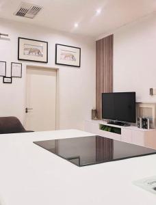 a living room with a tv and a glass table at Maerua Mall Units LUXE ACCOMMODATION in Windhoek