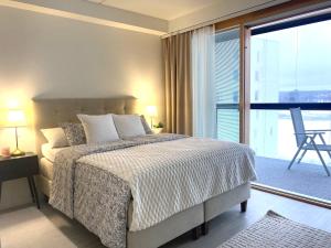 a bedroom with a bed and a large window at Sky Studio - free parking and lake view in Jyväskylä