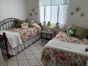 a bedroom with two beds and a window at Turlocks Little Palace in Turlock