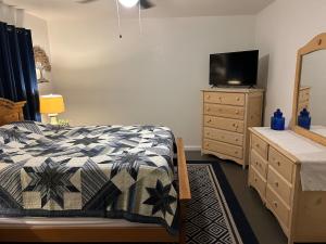 a bedroom with a bed and a dresser with a television at Turlocks Little Palace in Turlock