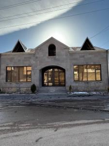 a large stone house with windows on a street at Elen Apartment Goris in Goris