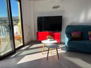 a living room with a couch and a table and a tv at Ap. con piscina, Moraira centro. in Moraira