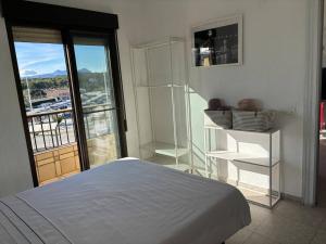 a bedroom with a bed and a large window at Ap. con piscina, Moraira centro. in Moraira +60 photos