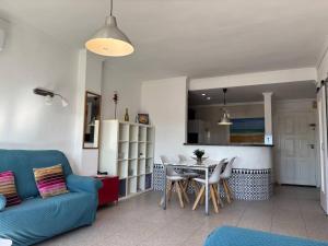 a living room with a blue couch and a table at Ap. con piscina, Moraira centro. in Moraira