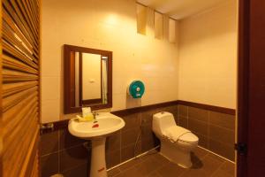 y baño con lavabo, aseo y espejo. en Palms Hill Resort en Phangnga