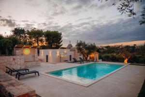 a swimming pool in a yard with a house at Trullo Alisia - TrulloExperience in Putignano
