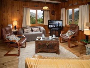 a living room with a couch and chairs and a tv at Chalet Le Katanga by Interhome in Ovronnaz