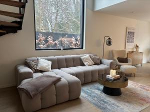 a living room with a couch and a table at Luxe woning met verwarmd zwembad in Genk