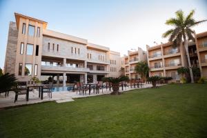 a courtyard with tables and chairs in a building at Panacea Suites Hotel in Borg El Arab