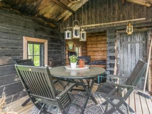 a patio with a table and chairs in a cabin at Holiday Home Kelo-kolo by Interhome in Iisalmi