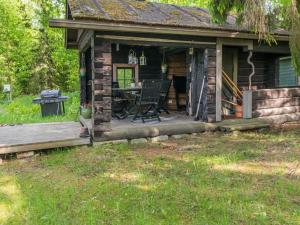 a cabin with a table and a grill on the porch at Holiday Home Kelo-kolo by Interhome in Iisalmi