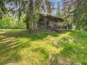 a log cabin with a tree in front of it at Holiday Home Kelo-kolo by Interhome in Iisalmi