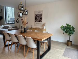 a dining room with a wooden table and chairs at Luxe woning met verwarmd zwembad in Genk +33 photos