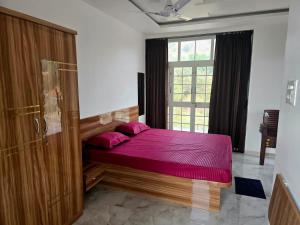 a bedroom with a bed with purple sheets and a window at Devs Villa Amansara above the sky in Pune