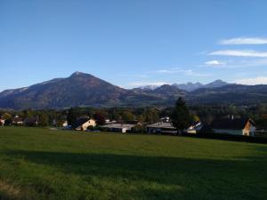 a field of grass with mountains in the background at Escale à Boisinges in Viuz-en-Sallaz