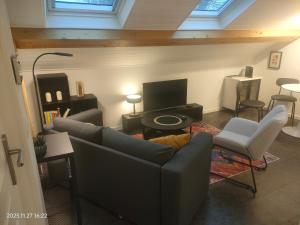 a living room with a couch and a tv at WhiteHouse Lozère in Palaiseau