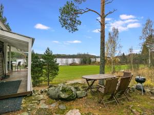 a patio with a table and chairs and a grill at Holiday Home Koskiharju by Interhome in Säynetlahti