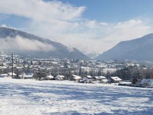 a snow covered field with a city in the background at Escale à Boisinges in Viuz-en-Sallaz +7 photos