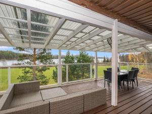 a screened porch with a table and chairs at Holiday Home Koskiharju by Interhome in Säynetlahti