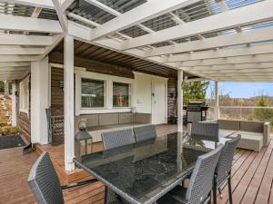 a patio with a glass table and chairs on a deck at Holiday Home Koskiharju by Interhome in Säynetlahti