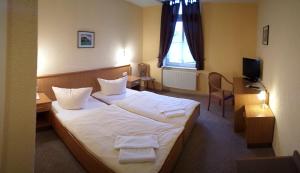 a hotel room with a bed with towels on it at Hotel Schützenhaus in Bad Düben