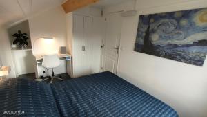 a bedroom with a bed and a desk and a painting at WhiteHouse Lozère in Palaiseau