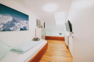 a bedroom with a bed and a tv and a tub at Mooslodge in Kaprun