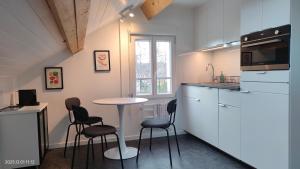 a kitchen with a table and chairs in a kitchen at WhiteHouse Lozère in Palaiseau