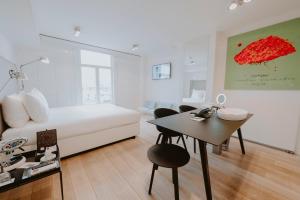 a bedroom with a bed and a table and a desk at Boutique Hotels MANNA & Blue in Nijmegen