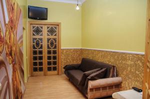 a living room with a couch and a tv on a wall at Golden Globus Hostel in Kyiv