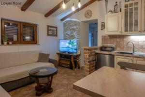 a living room with a couch and a kitchen with a tv at Casa Romina in Višnjan