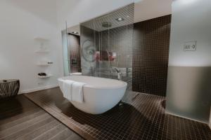 a bathroom with a large tub and a shower at Boutique Hotels MANNA & Blue in Nijmegen +33 photos