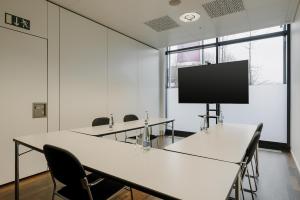 a conference room with tables and chairs and a flat screen tv at Prize by Radisson, Zurich Affoltern am Albis in Affoltern