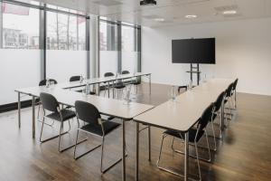 a conference room with tables and chairs and a screen at Prize by Radisson, Zurich Affoltern am Albis in Affoltern