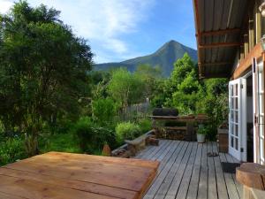 a wooden deck with a table and a view of a mountain at Boutique Vintage Forest Cabin in Stormsrivier