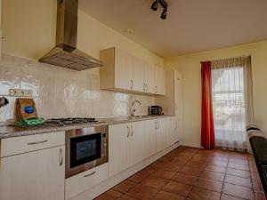 a kitchen with white cabinets and a stove top oven at Apartment Westergeest 2 by Interhome in Uitgeest +24 photos