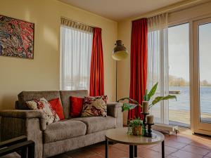 a living room with a couch and a table at Apartment Westergeest 2 by Interhome in Uitgeest