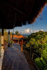 a wooden walkway leading to a resort with a cactus at Alizées Moreré in Ilha de Boipeba +52 photos