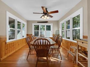a dining room with a table and chairs and windows at Rockin Rhody Retreat in Rhododendron